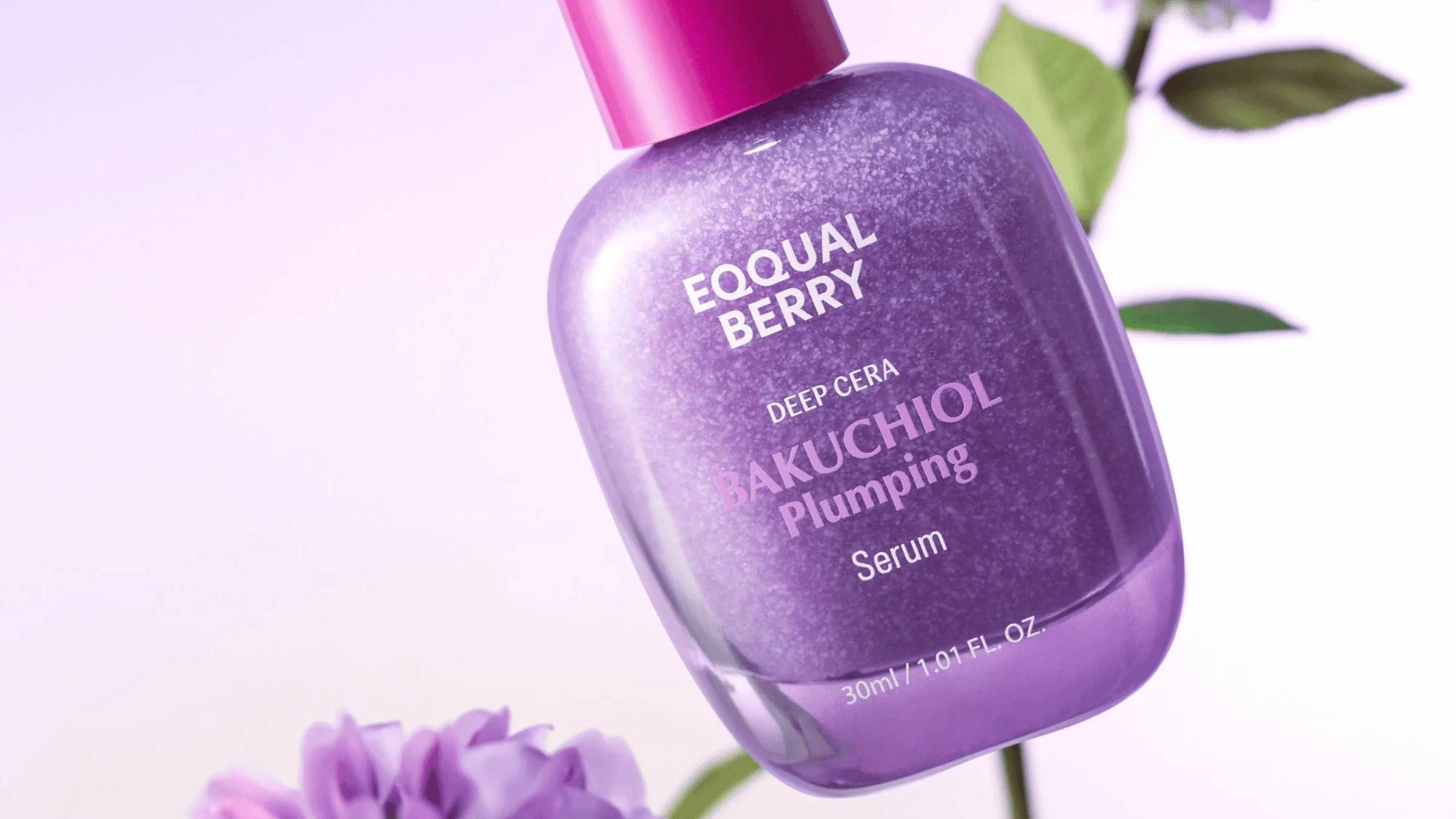 Equal Berry Bakuchiol Plumping Serum i en lila skimrande flaska med rosa kork. Bakgrund med blommor och blad i mjuka pastelltoner.