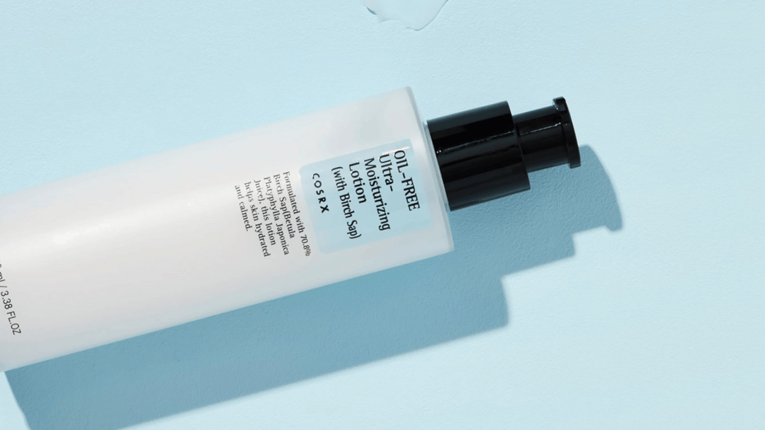 En liggande tub av COSRX Oil-Free Ultra-Moisturizing Lotion på en blå bakgrund med en skugga.