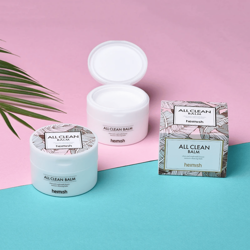 Heimish All Clean Balm 120ml och en palm på rosa och blå bakgrund, lämplig för känslig hud.