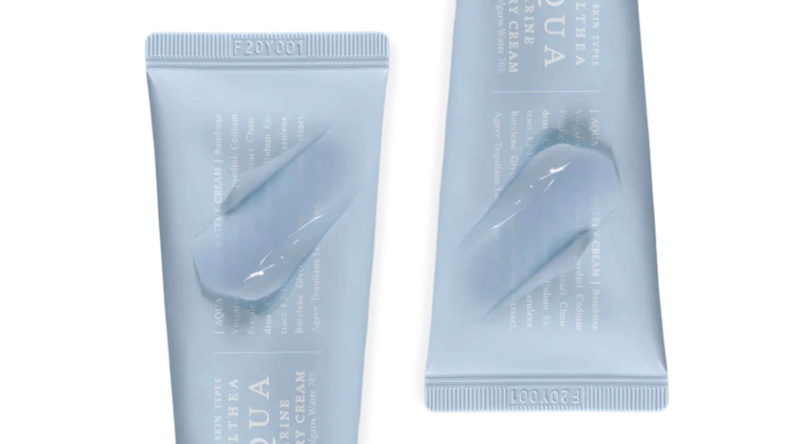 En person håller en rosa tub av Beauty of Joseon ansiktsolja mot sin axel, med en neutral bakgrund.