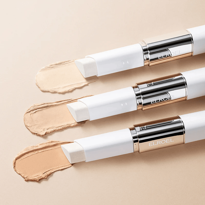 ELROEL Blanc Cover Cream Stick concealer with a built-in brush, several sticks lined up showing the product's design and application.