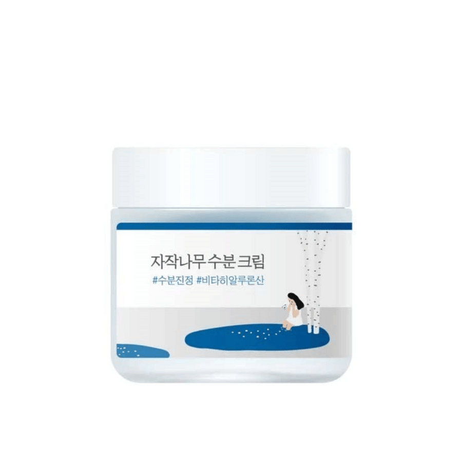 Round Lab Birch Juice Moisturizing Cream i transparent burk med vit lock och blå etikett med illustration av björk och flicka, frilagd mot vit bakgrund.