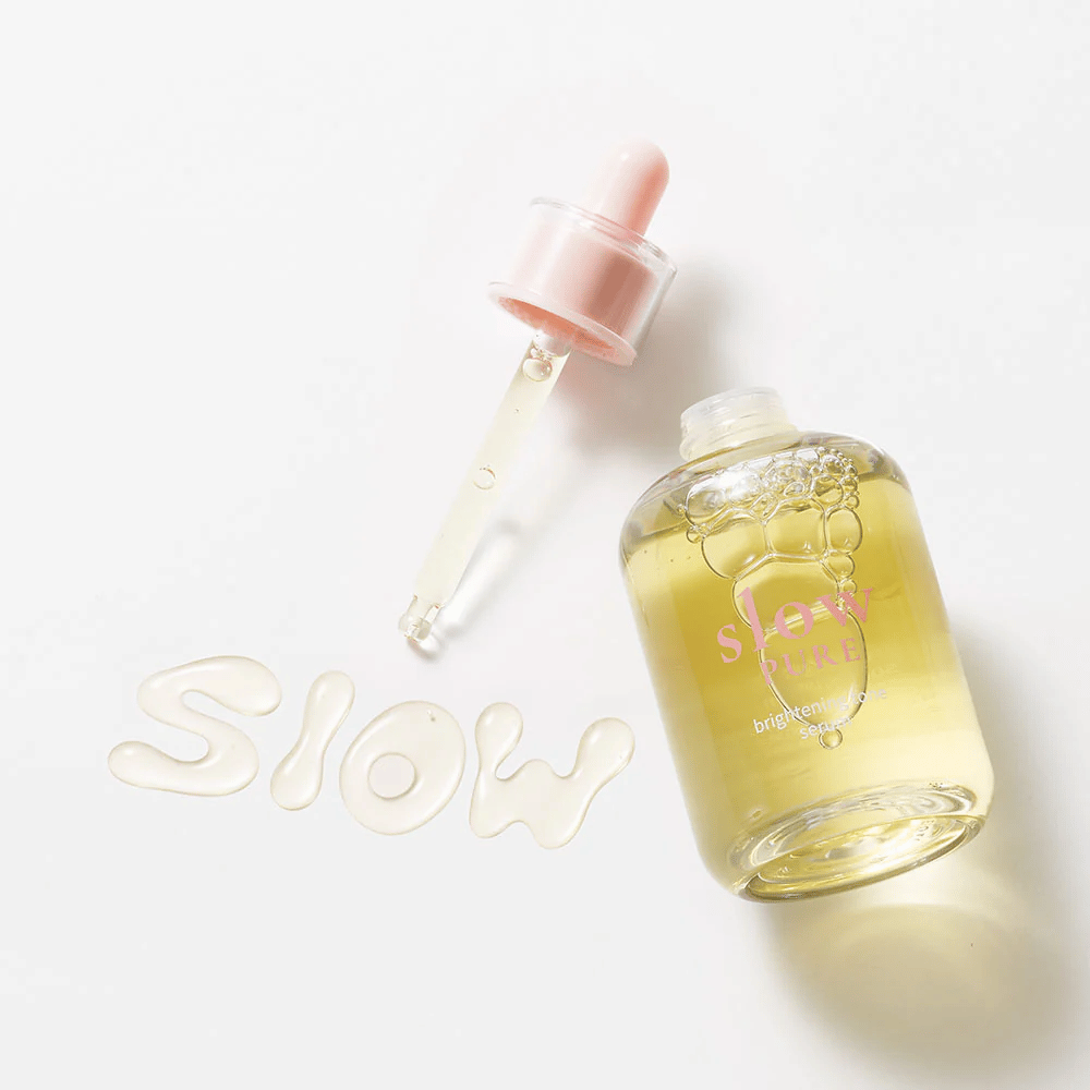 Slow Pure Brightening Tone Serum with an open dropper, text written in serum on the surface: "Slow".