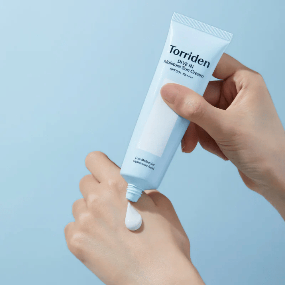 Torriden DIVE-IN Moisture Sun Cream SPF50+ PA++++ applied on the hand to show the light and creamy texture of the moisturizing sunscreen.