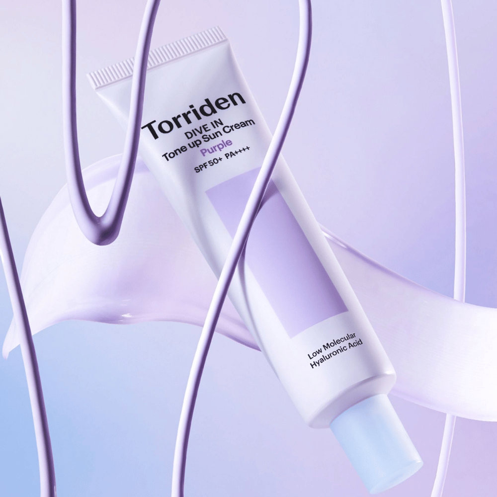 Torriden DIVE IN Tone Up Sun Cream Purple SPF50+ PA++++ presented in a creative product setting with purple details that highlight the moisturizing formula.