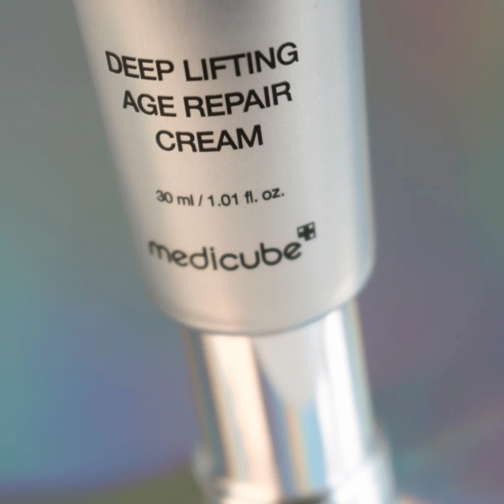 Close-up of Medicube Deep Lifting Age Repair Cream in silver packaging, 30 ml.