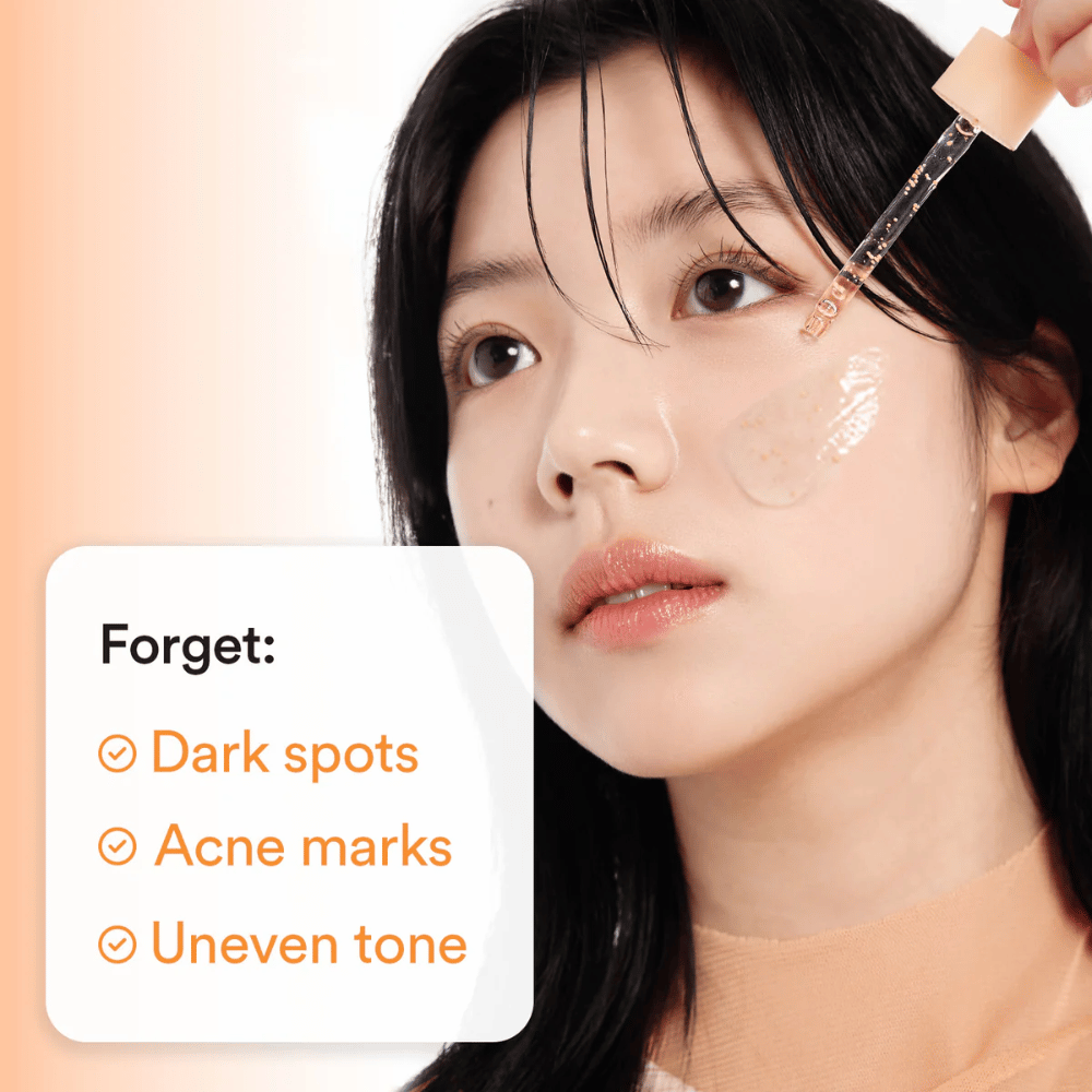 Woman applying serum with a dropper on the cheek. Text on the image lists Benefits: "Forget: Dark spots, Acne marks, Uneven tone".