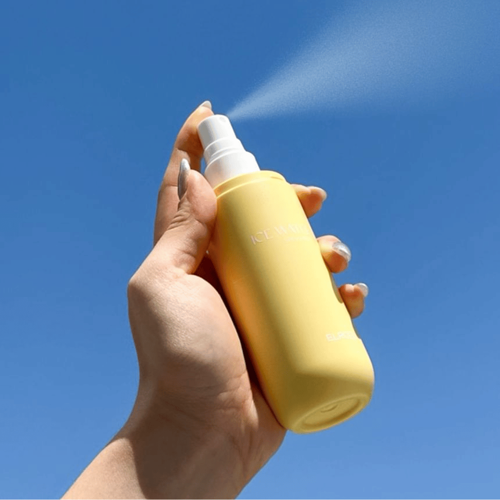 ELROEL Ice Water Sun Mist SPF 40 PA+++ sun mist sprayed from bottle against a blue sky, lightweight sun protection that moisturizes and refreshes the skin