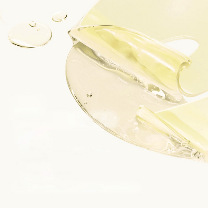 Närbild på Medicube Kojic Acid Turmeric Brightening Gel Mask – genomskinlig gelmask med gyllene ton och synliga serumdroppar.