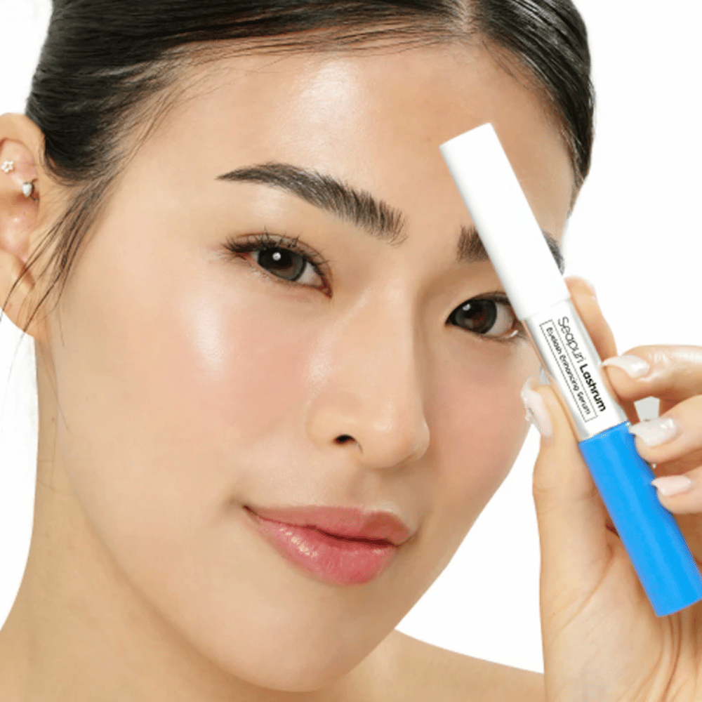 Woman holding Seapuri Lashrum Eyelash Enhancing Serum. A nourishing lash serum that strengthens and defines lashes.