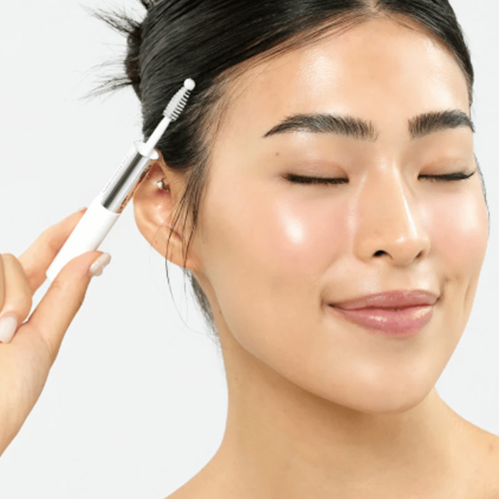 Woman applies Seapuri Lashrum Eyelash Enhancing Serum to eyelashes. Promotes natural growth and shine.