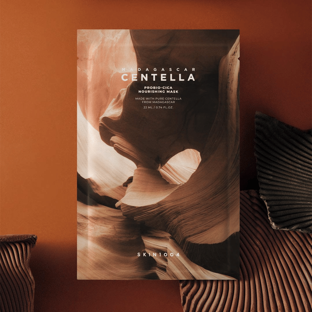 Sheet mask packaging from SKIN1004 against a warm brown background with a nature-inspired design.