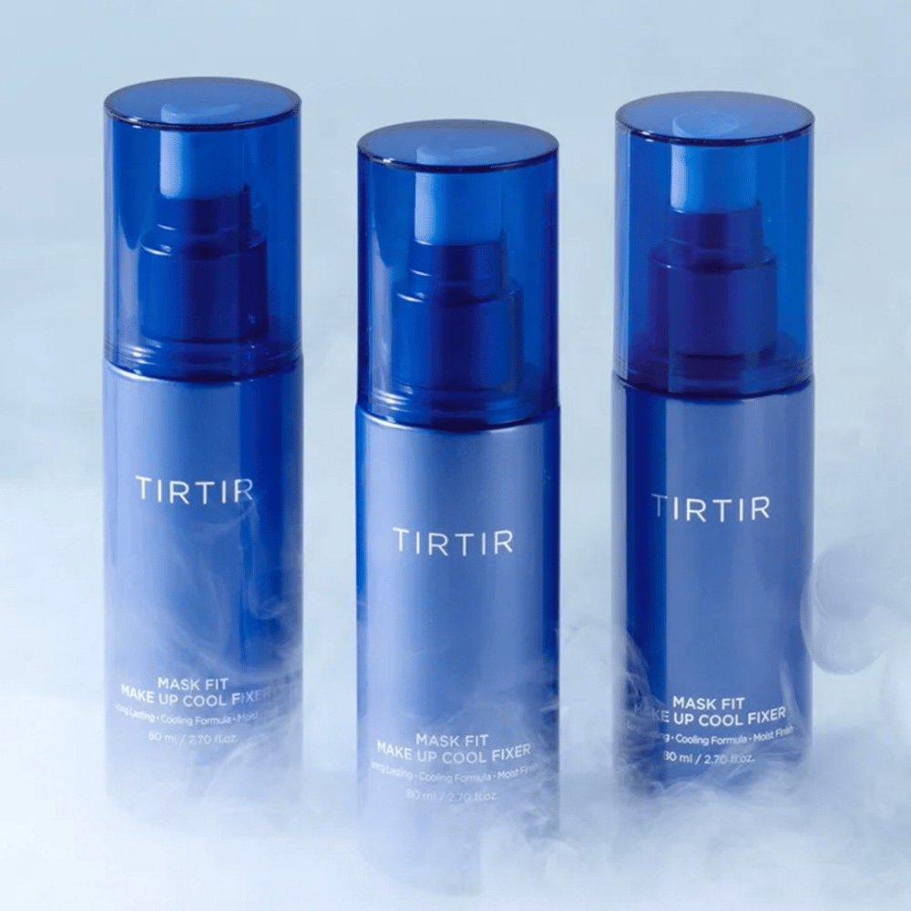Three blue spray bottles with "TIRTIR Mask Fit Make Up Cool Fixer" on the label. Each bottle holds 80 ml (2.70 fl. oz.) and is designed to provide a cooling sensation and long-lasting makeup. The bottles stand on a light background with mist to create an atmosphere of freshness.