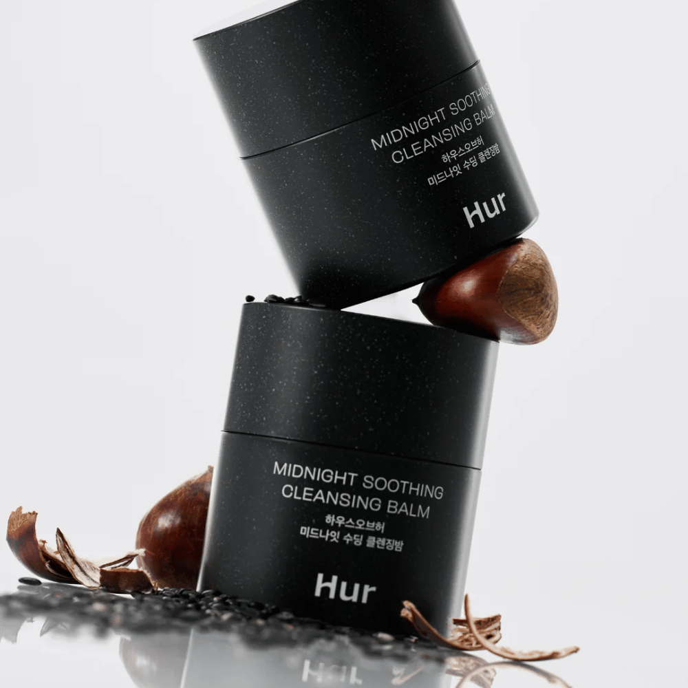 Two jars of How Midnight Soothing Cleansing Balm stacked with natural ingredients. Nourishing cleansing balm for daily cleansing of sensitive skin.