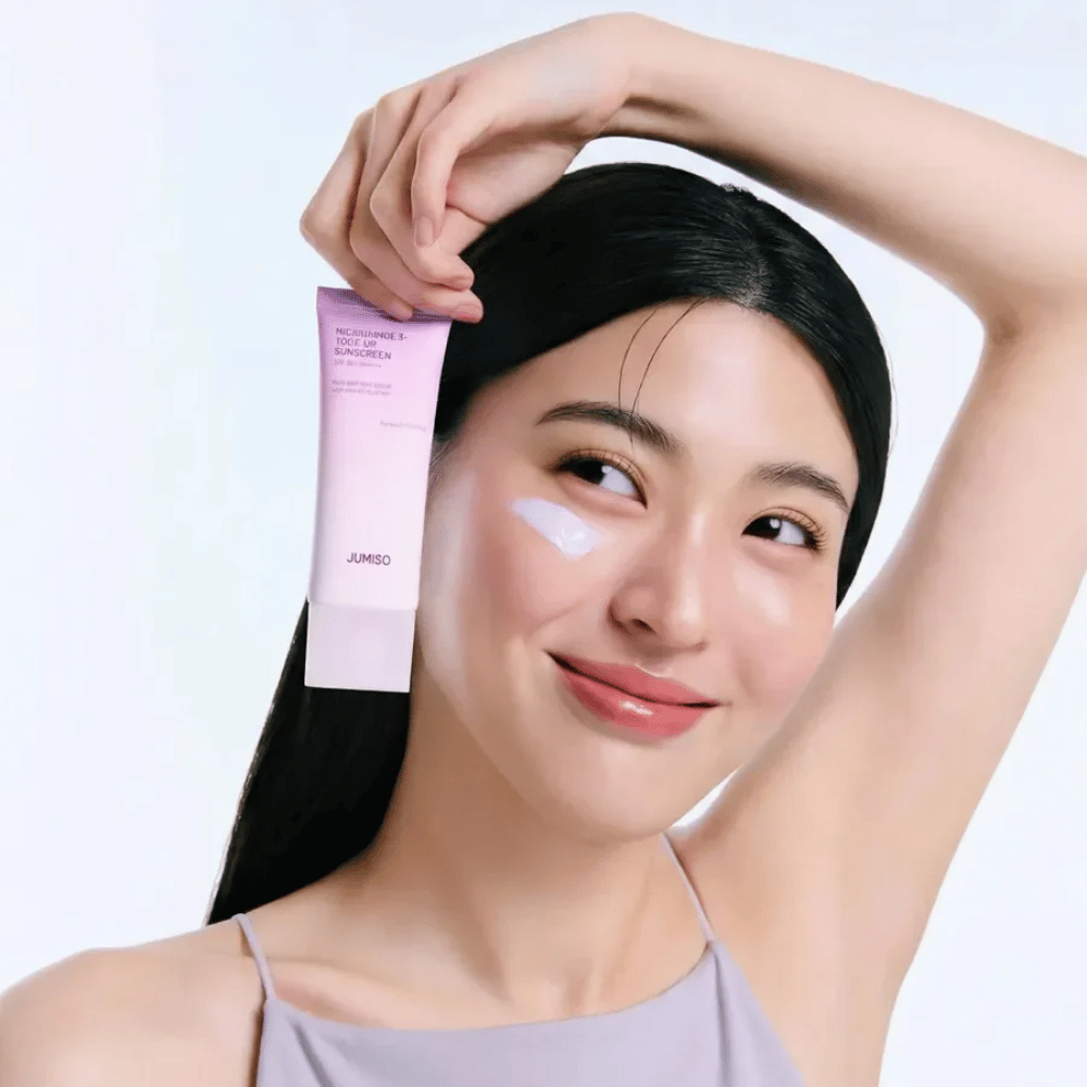 Model is holding JUMISO Niacinamide 3+ Tone-Up Sunscreen SPF50+ PA++++ – sunscreen with niacinamide that evens out skin tone and protects the skin.