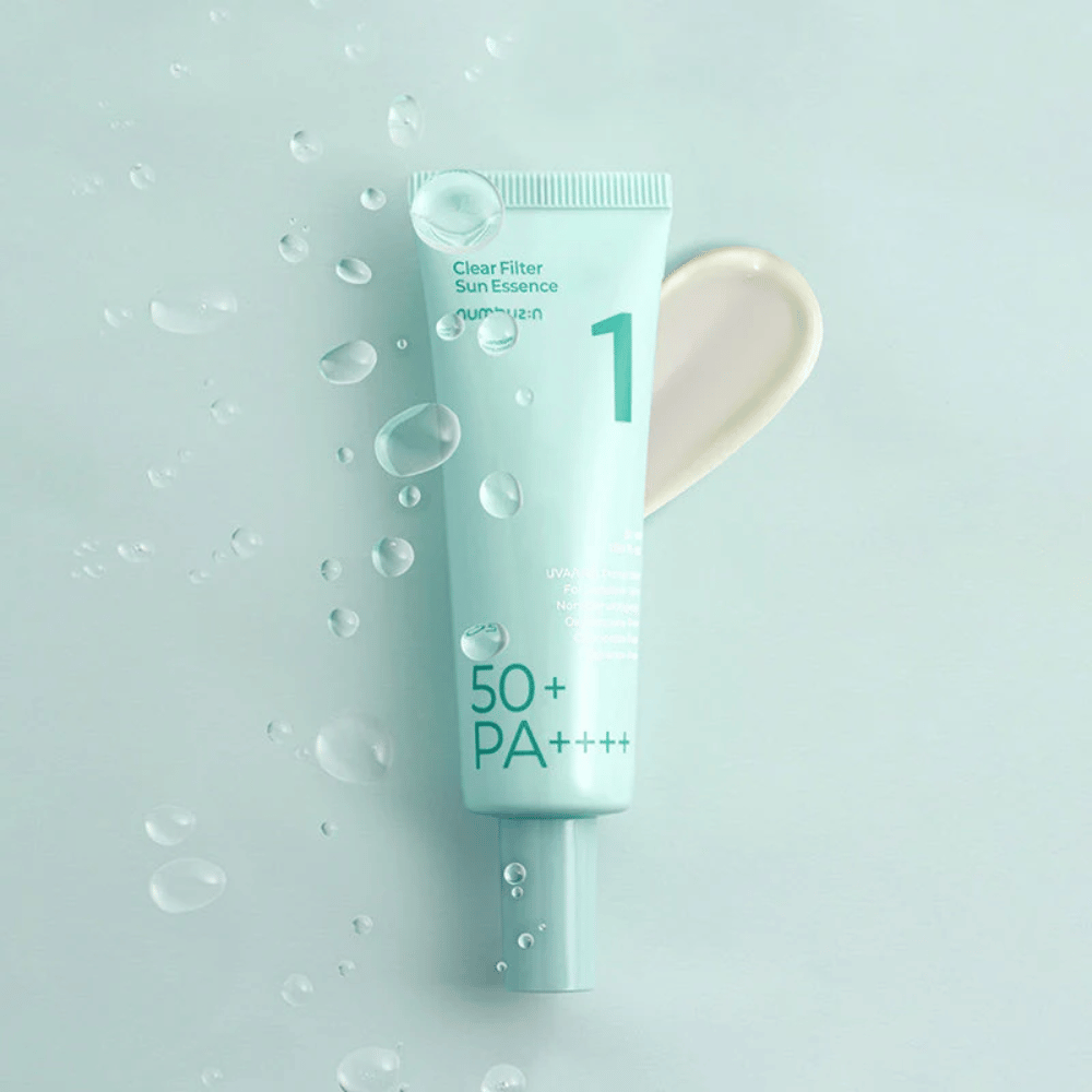 A light blue tube with No.1 Clear Filter Sun Essence SPF 50+ PA++++. The tube is decorated with water droplets and a dab of the product is shown next to it. The product is designed to provide high sun protection factor and protection against UVA/UVB rays.