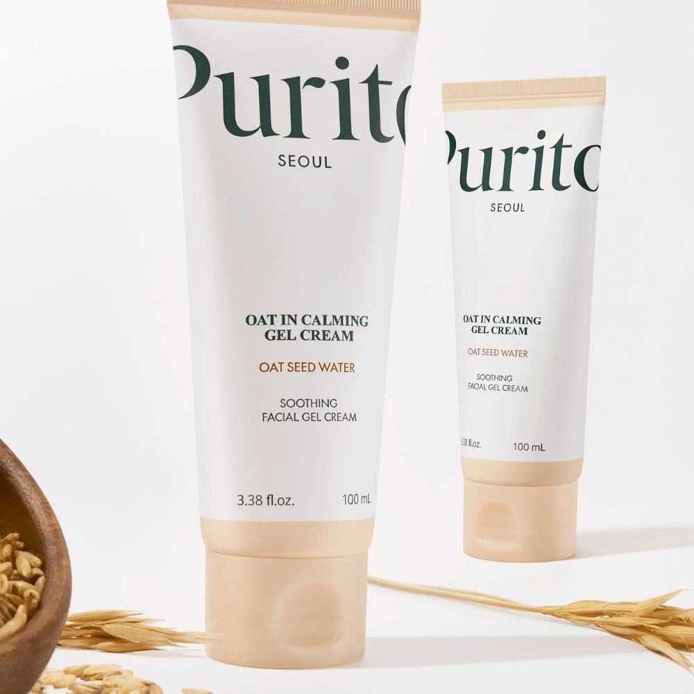 Purito Oat-In Calming Gel Cream in beige tube, placed with oat grains. Soothes sensitive skin with oat water and light gel texture.