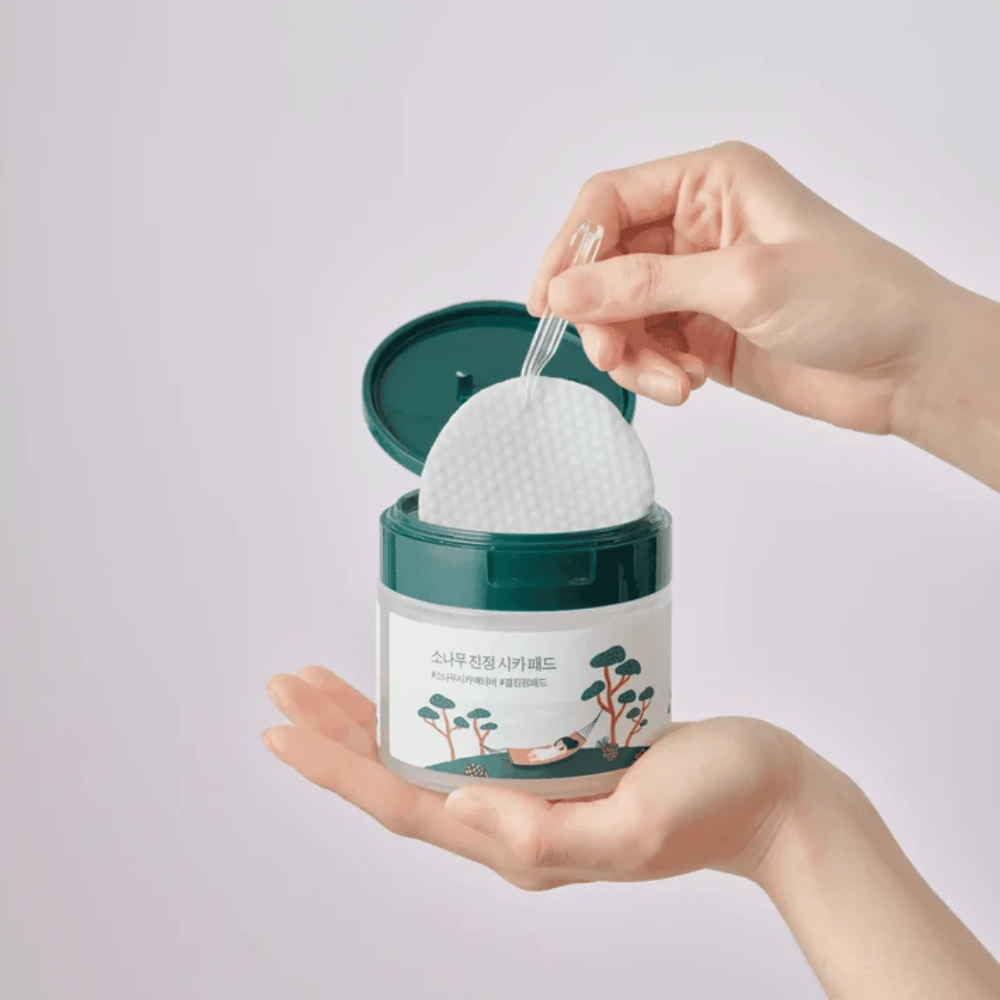 ROUND LAB Pine Calming Cica Pad – a toner pad being taken out of the jar with the included tweezers