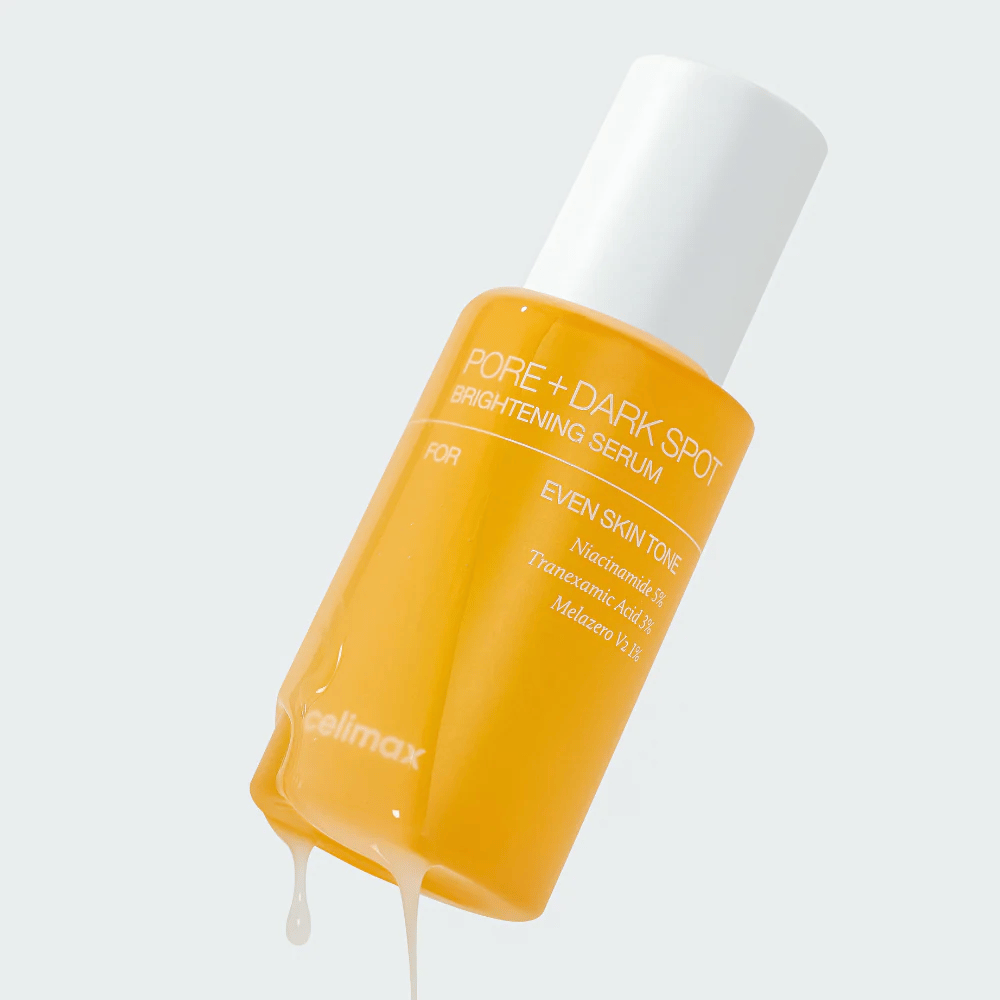 Celimax Pore + Dark Spot Brightening Serum in a yellow bottle with a white cap, drops of serum run along the bottle.