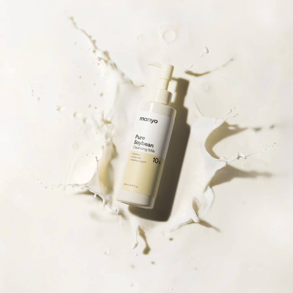 1. Ma:nyo Pure Soybean Cleansing Milk – gentle cleansing milk with soy in a pump bottle surrounded by milk splashes on a light background