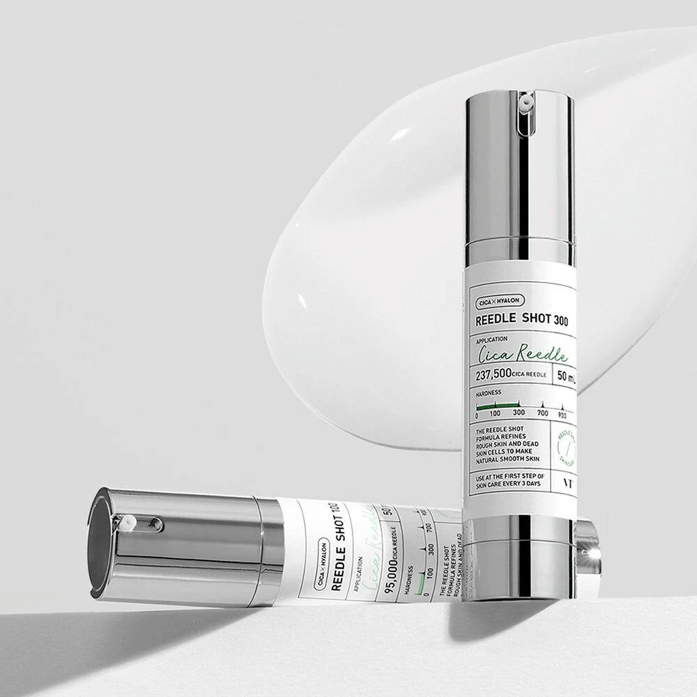 Two bottles of Reedle Shot 300 and Reedle Shot 100 stand against a light background. The products have a modern design with silver-colored pumps and clear labeling. Reedle Shot 300 contains 237,500 Cica Reedle, intended to improve skin texture and moisture.
