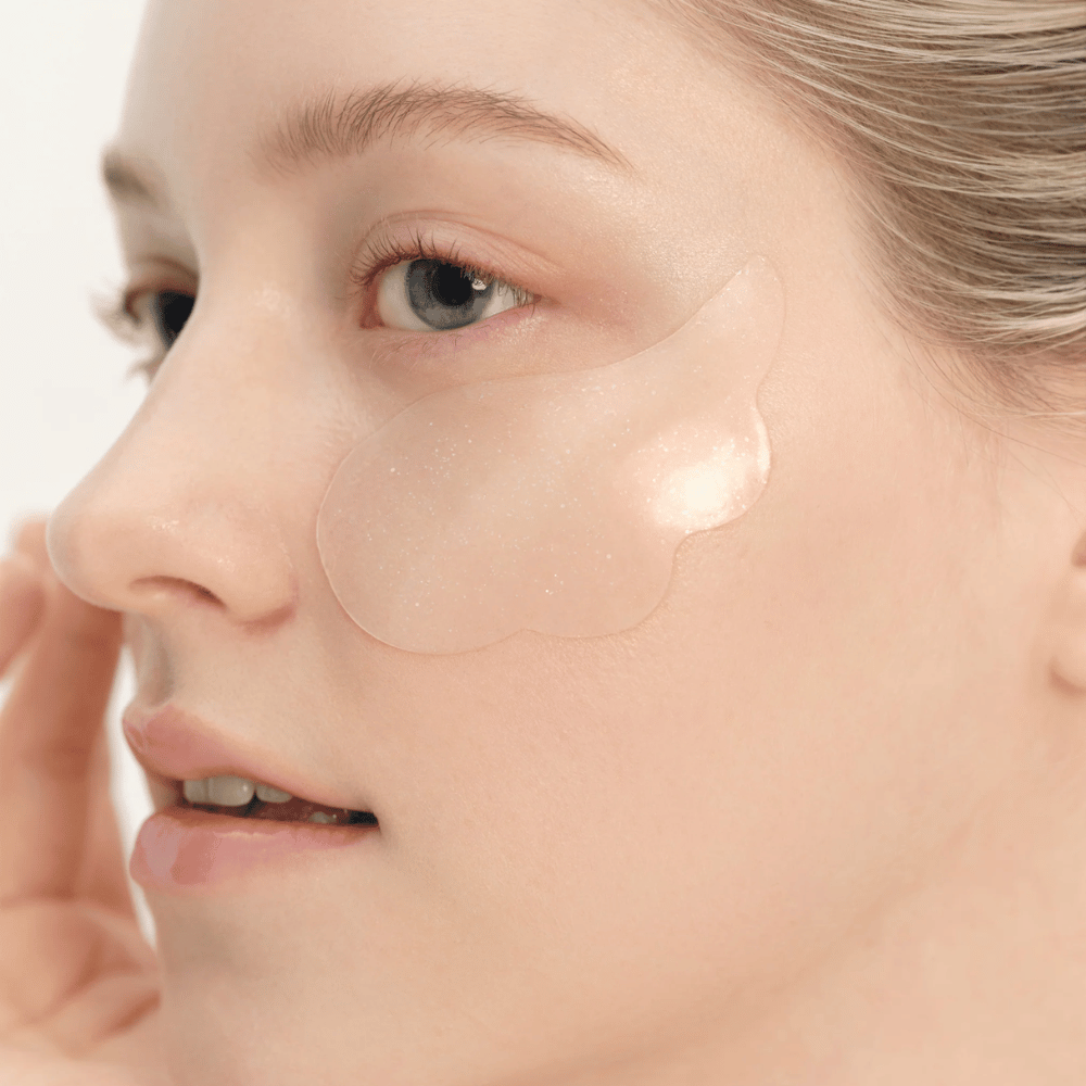 Close-up of a model applying Beauty of Joseon under eye patch under the eye for hydration, glow, and firming effect.