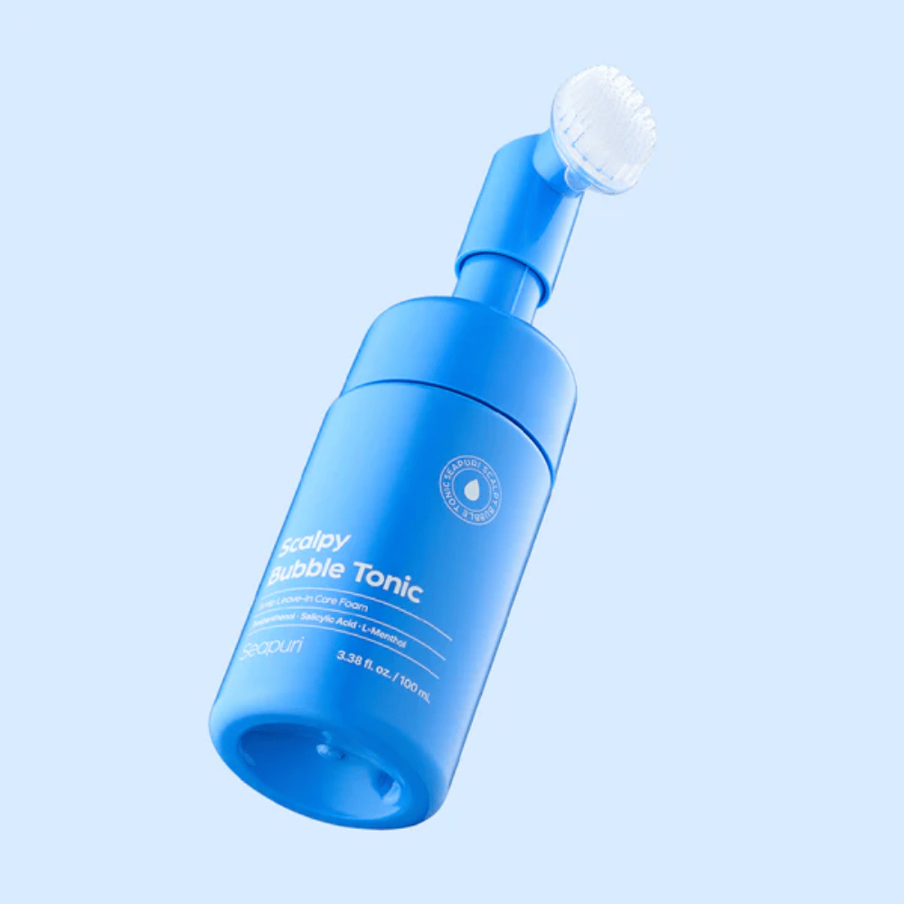 Stylish product image of Seapuri Scalpy Bubble Tonic against a light blue background that highlights the modern design and the unique brush attachment for scalp care.