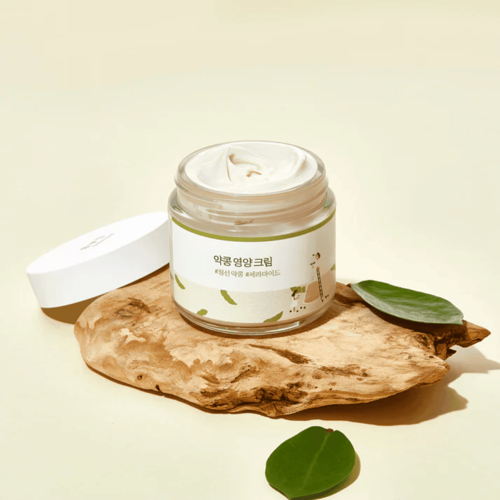 Mixsoon Soybean Nourishing Cream in an open jar on a wooden piece with green leaves. A nutrient-rich cream with fermented soybeans and ceramides.