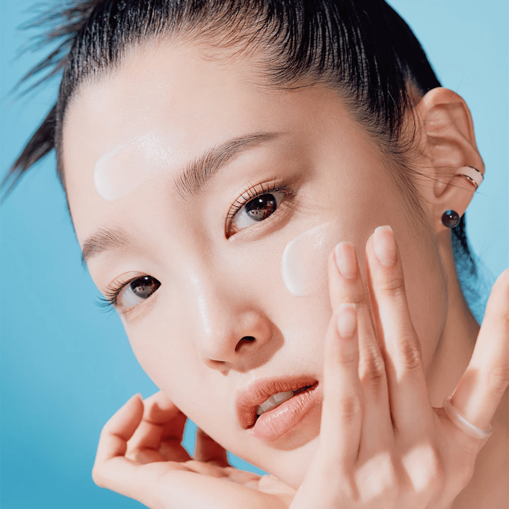 A woman poses with her hands on her face in a TOCOBO Bio Watery Sun Cream SPF50+ PA++++ 50ml natural skincare campaign.