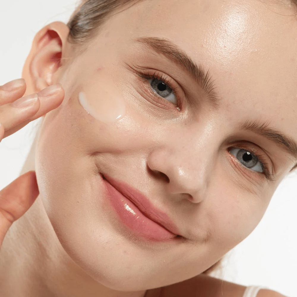 Model applying Medicube Zero Pore Serum 2.0 on the cheek, a pore-refining serum that provides smoother skin texture, hydration, and a natural glow.