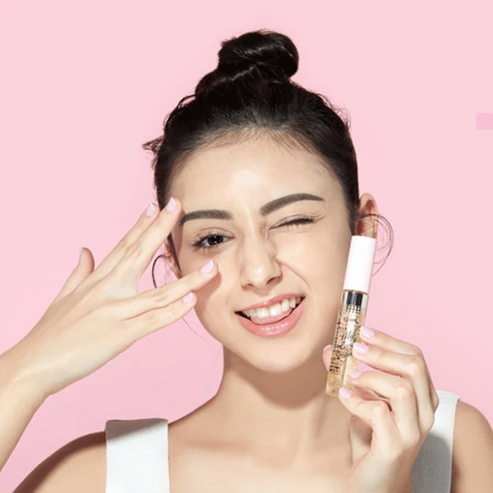 A woman holds a bottle of ETUDE My Lash Serum 9g to her face to strengthen eyelashes.
