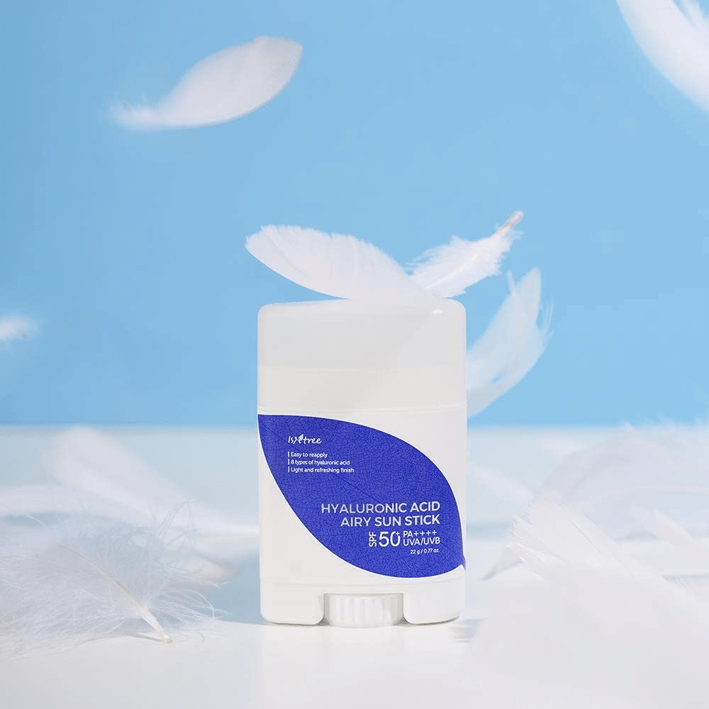 A Isntree Hyaluronic Acid Airy Sun Stick with SPF 50+ and Hyaluronic Acid, adorned with white feathers.