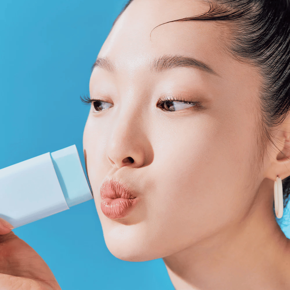 A woman uses a TOCOBO Cotton Soft Sun Stick SPF50+ PA++++ 19g to clean her face.